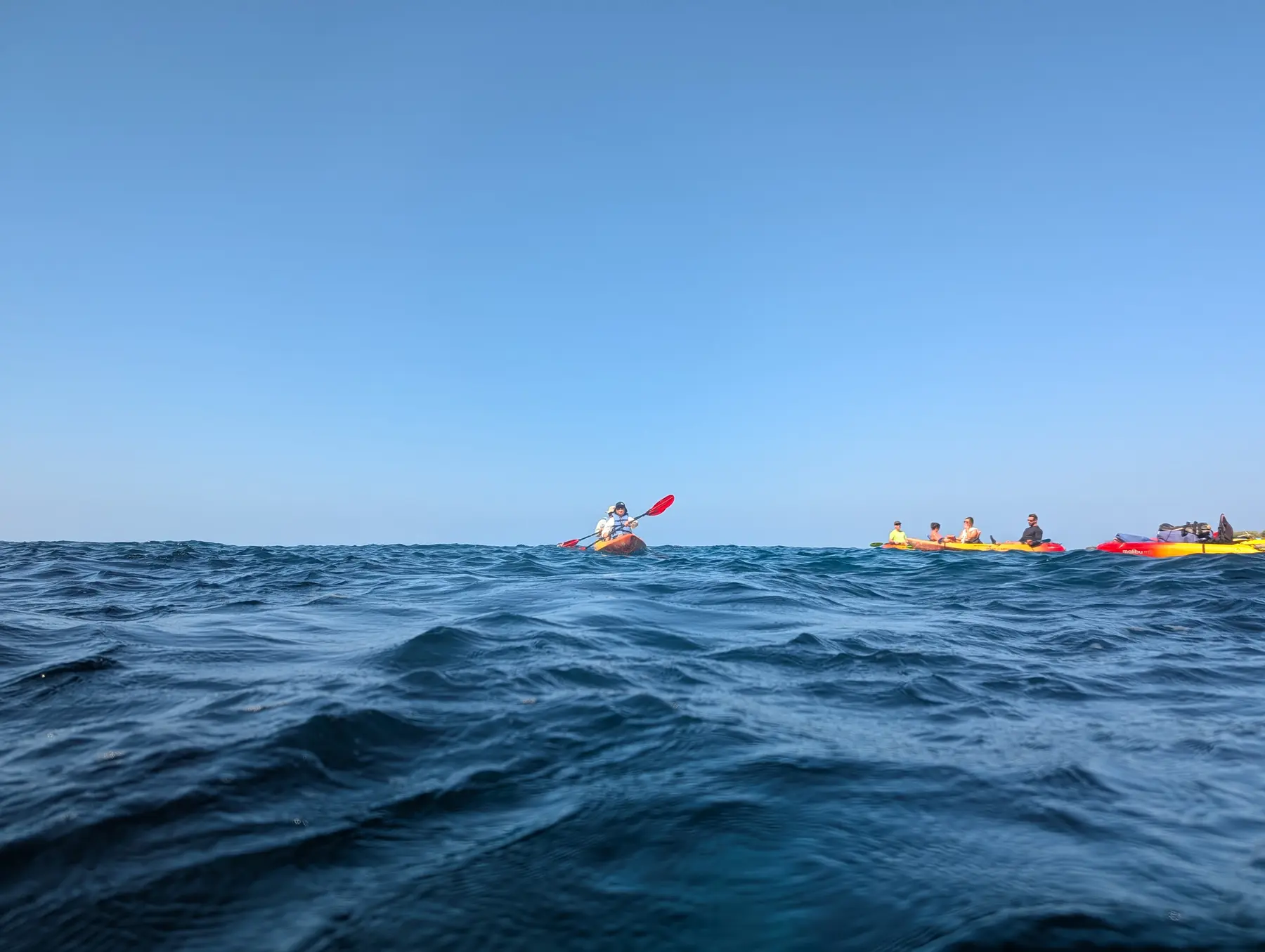 Kayakers moving along the Kona horizon
