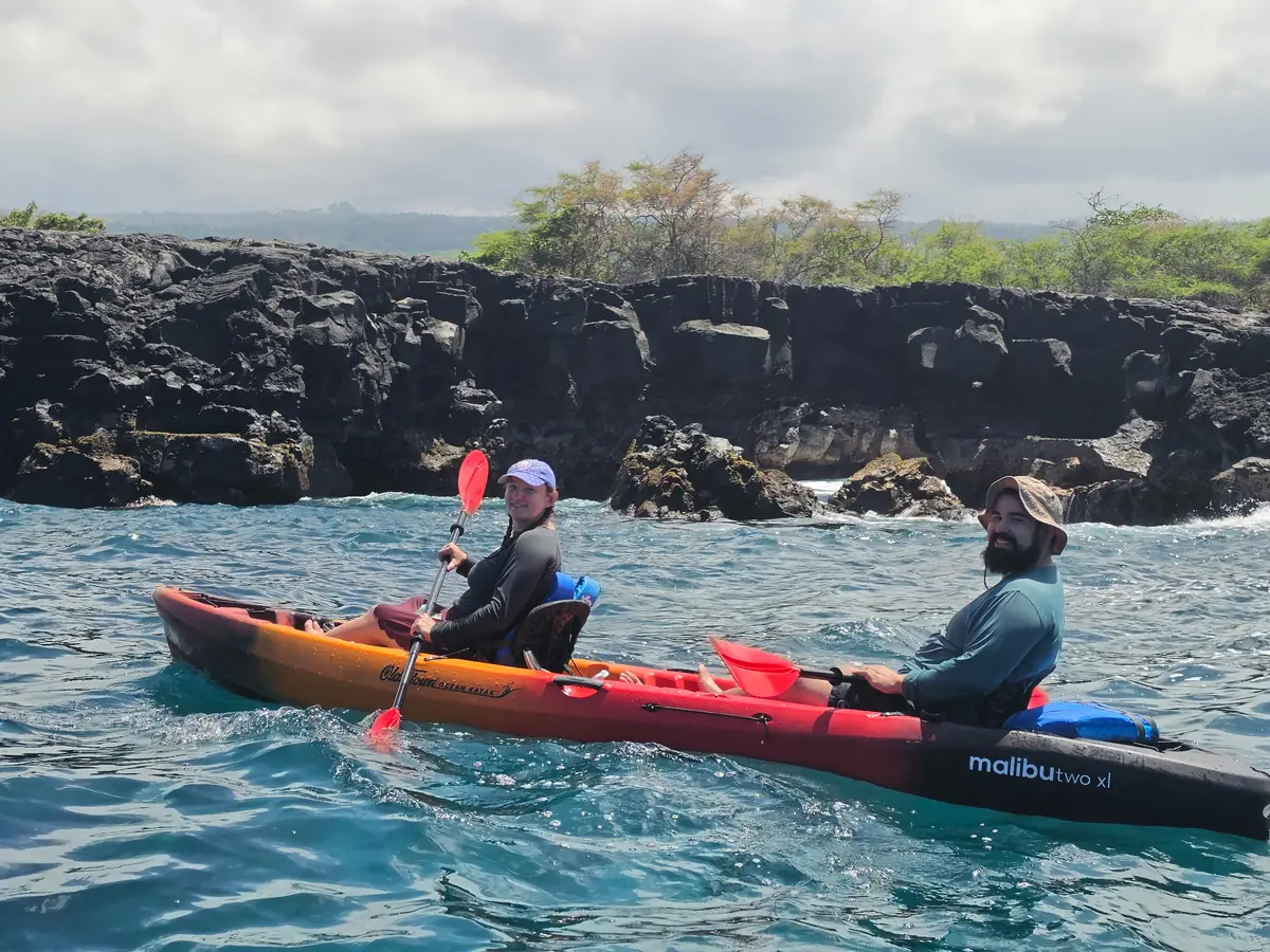 Guests paddling a new Malibu Two XL kayak along the lava coast